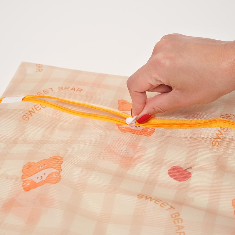 A hand opening a zipper on the Clean Pouch Zip Bag. 