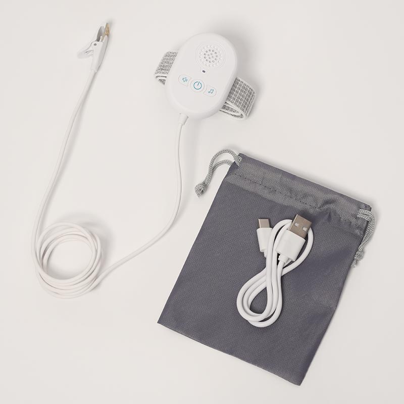 DreamDry Alarm with a storage bag and a charging cable. 