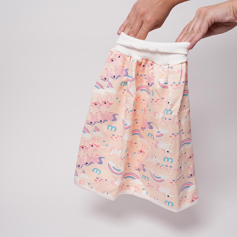 Hands holding and stretching the Loondie DreamWear Skirt pink. 
