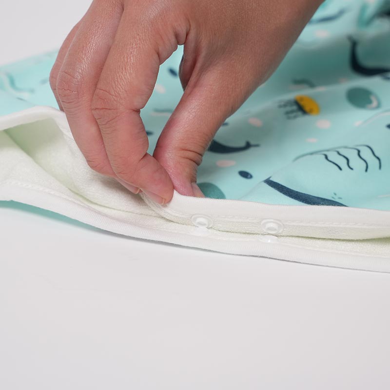 A hand interacting with Loondie DreamWear potty training pants by closing the buttons. 