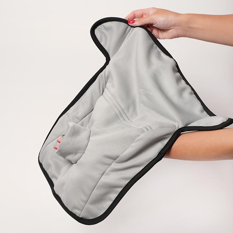 Hands holding a child seat protector, with an absorbent front and a non-slip back. 