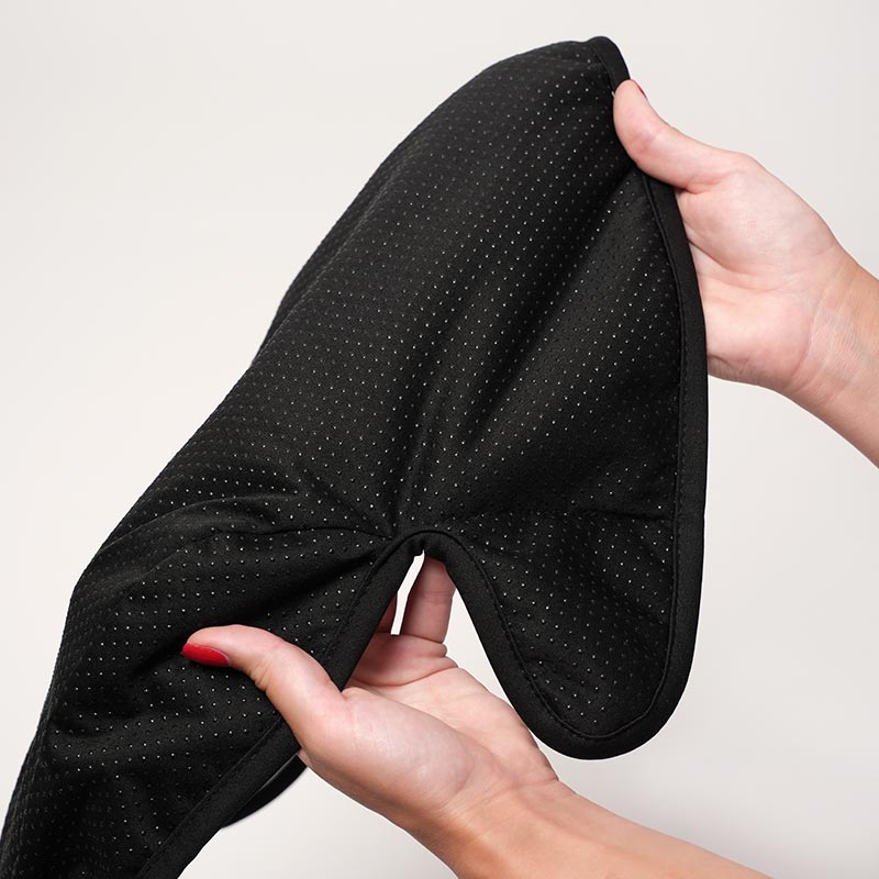 Woman's hands holding the Loondie DrySeat Protector and showing it's non-slip back. 