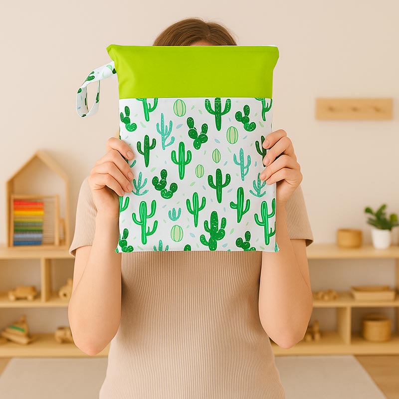 Woman showing her Cactus pattern DuoDry Wet Bag in her child's playroom. 