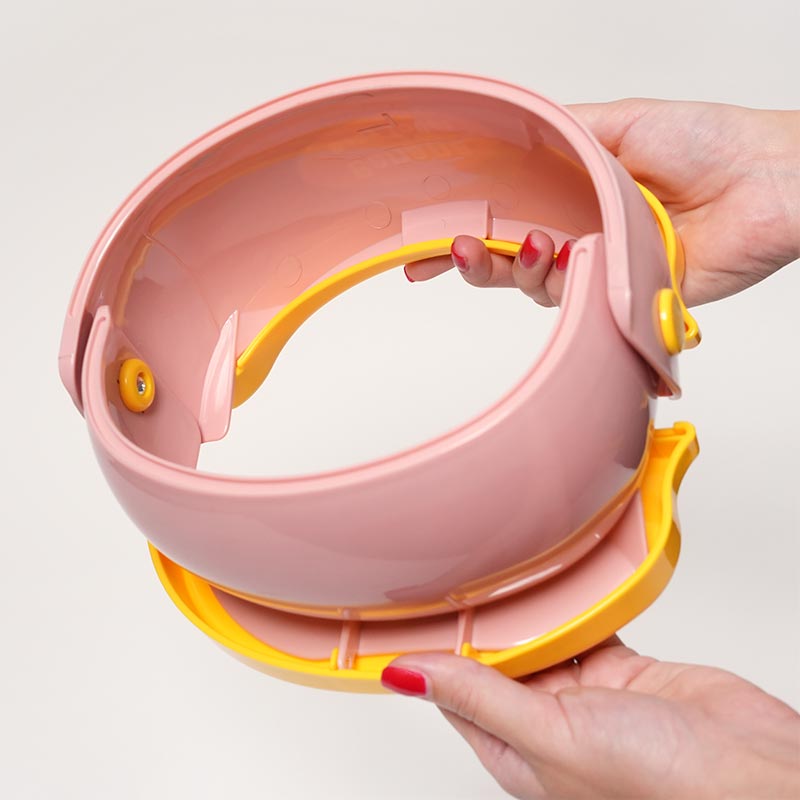 Hands holding the Loondie GoPotty upside down. 