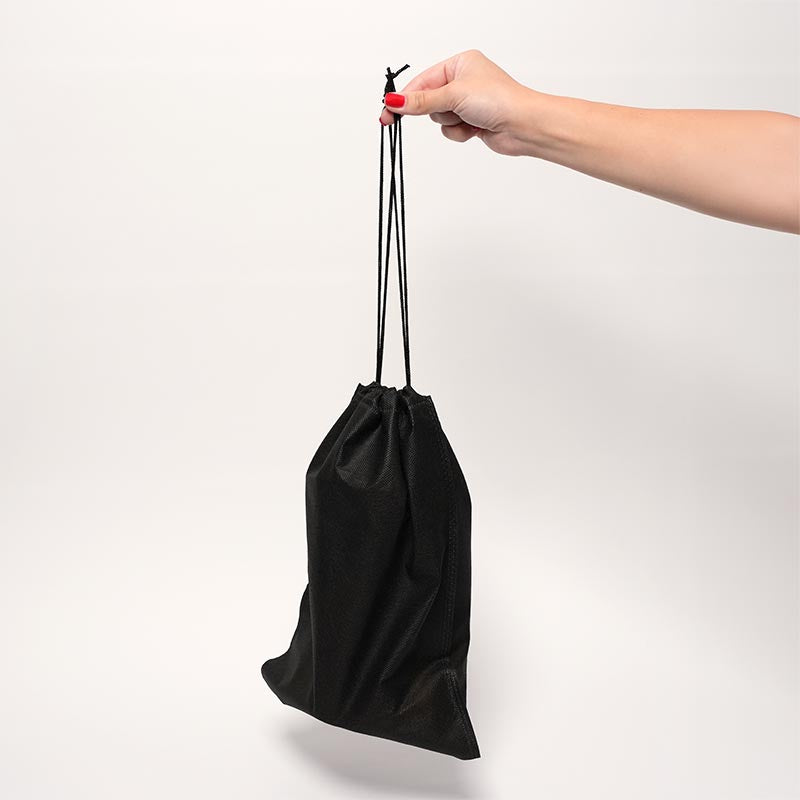 A hand holding a black storage bag of the Loondie GoPotty.