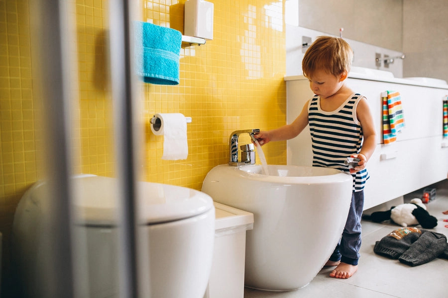 Kid playing with water in the bathroom