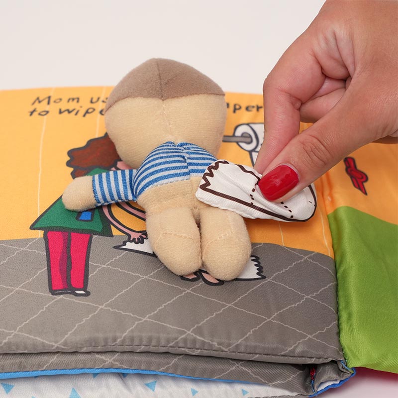 Woman's hand interacting with the Potty Buddy Book page that features a boy and the toilet paper.