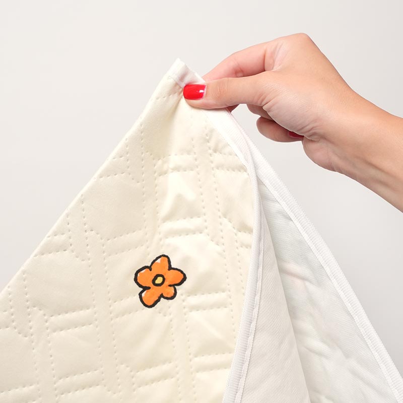 Close up on a hand holding the Waterproof DreamMat. 