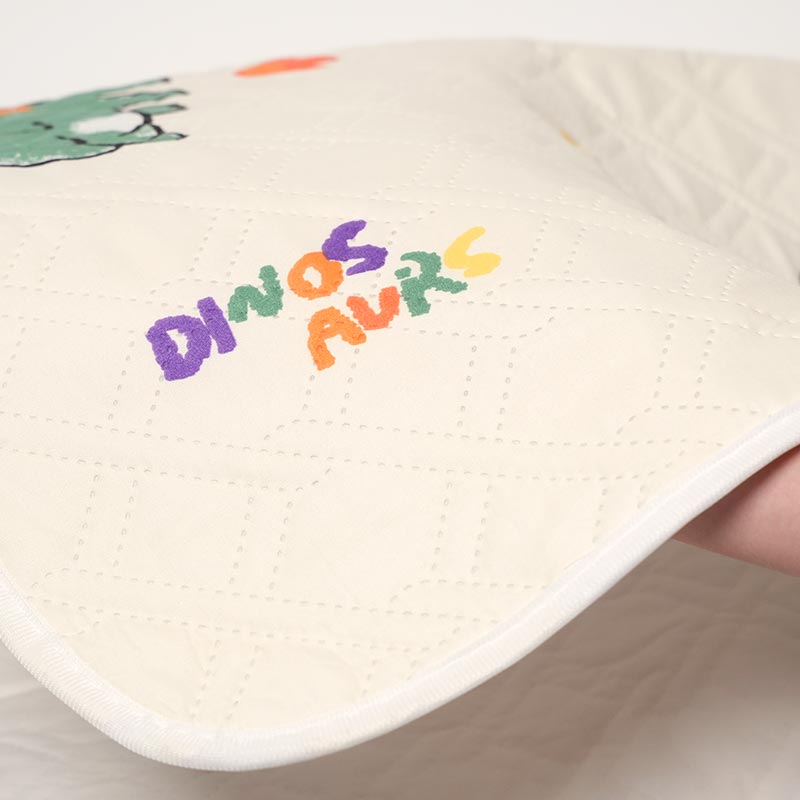 Close up on the Dino Waterproof Dream Mat material. 